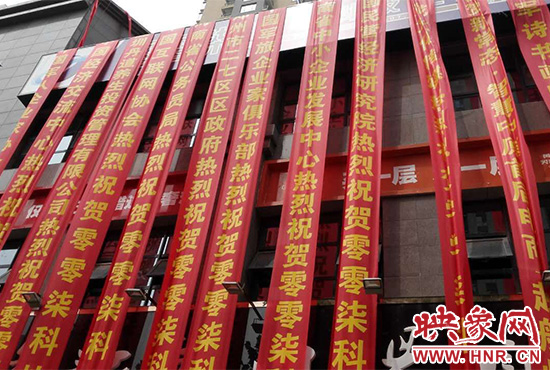 路邊一棟樓上懸掛著二三十條紅色條幅，全部是祝賀一家公司開(kāi)業(yè)的。