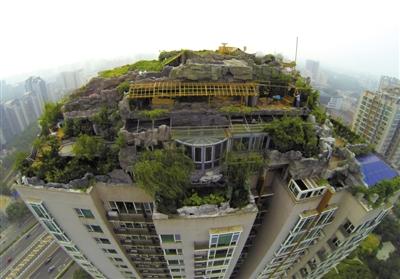 　　昨日，身穿橘黃色馬甲的工作人員在人濟(jì)山莊樓頂拆除違章建筑。新京報(bào)記者 吳江 攝