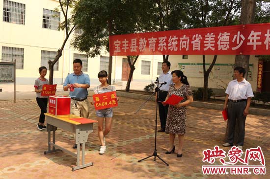 寶豐縣教育系統(tǒng)全體人員在石橋鎮(zhèn)中學(xué)為“美德少年”楊冠明同學(xué)捐款。