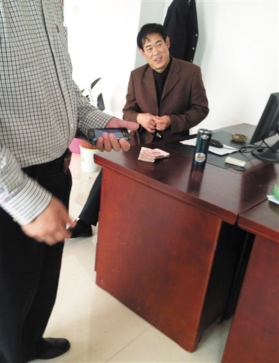 10月29日，獻縣國稅局稽查局辦公室內，一名企業(yè)主交了兩萬元現(xiàn)金在桌上。新京報記者 孟祥超 攝