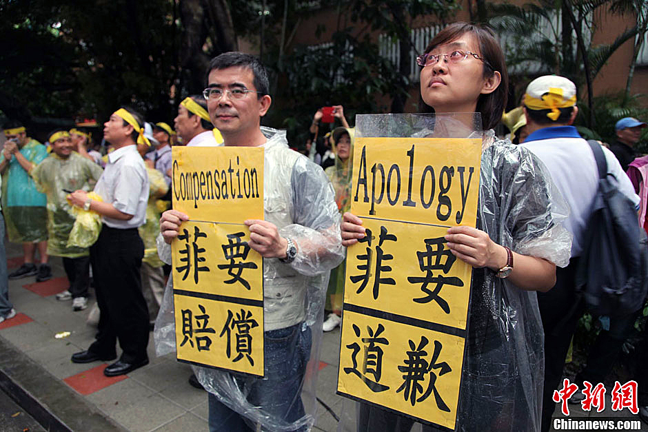 　圖為當(dāng)天下午，當(dāng)臺(tái)灣數(shù)百漁民在馬尼拉經(jīng)濟(jì)文化辦事處前抗議時(shí)，有兩名年輕人手持標(biāo)語(yǔ)，在路邊聲援。中新