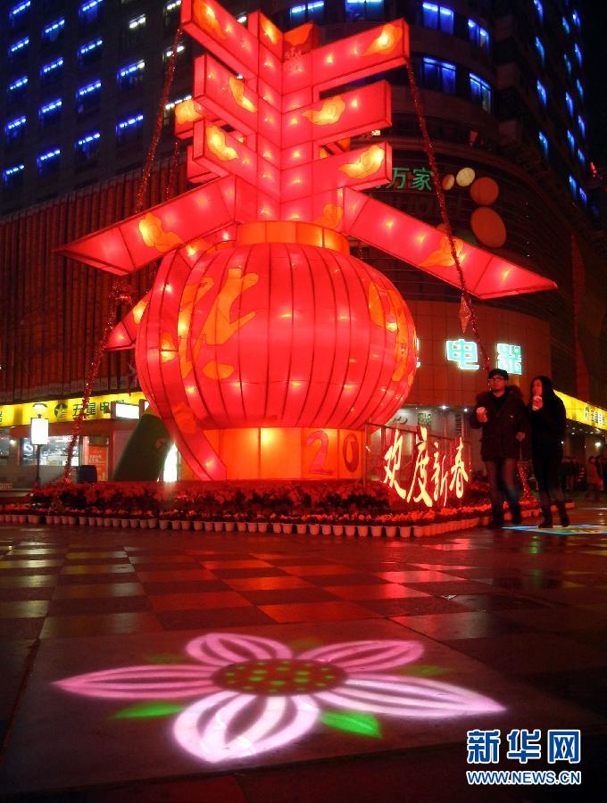 　1月30日晚，市民從蘇州市石路銀河廣場上大型“春”字彩燈景觀旁經(jīng)過。