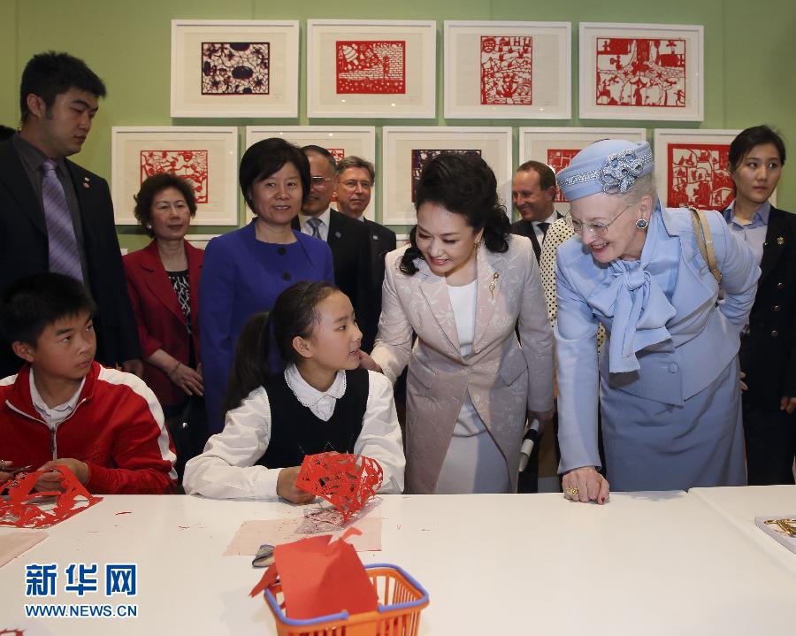 這是彭麗媛和瑪格麗特二世與根據(jù)安徒生童話中人物和情節(jié)制作剪紙的孩子交談。