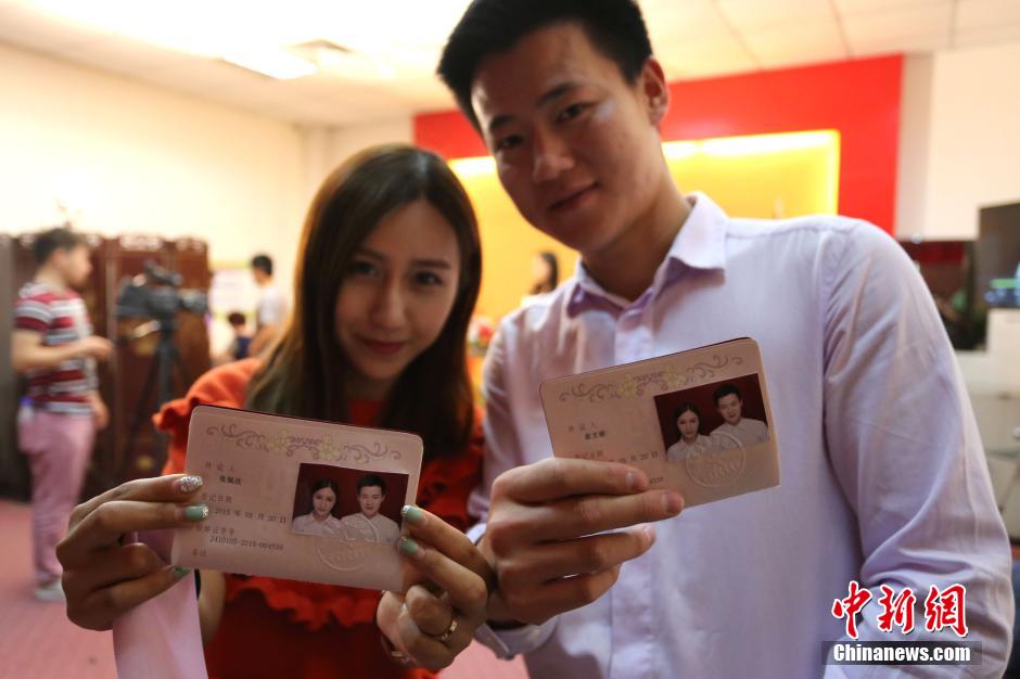 5月20日,河南鄭州,一對準(zhǔn)新人領(lǐng)完結(jié)婚證后秀自拍。