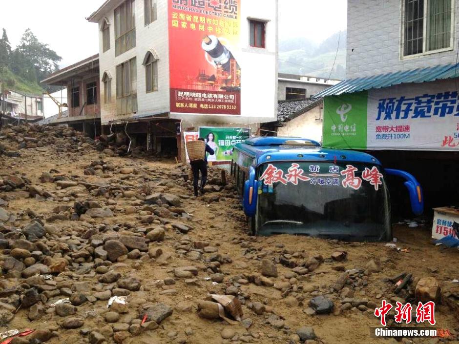 圖為山洪泥石流導(dǎo)沖進鄉(xiāng)鎮(zhèn)街道，導(dǎo)致客車被埋。