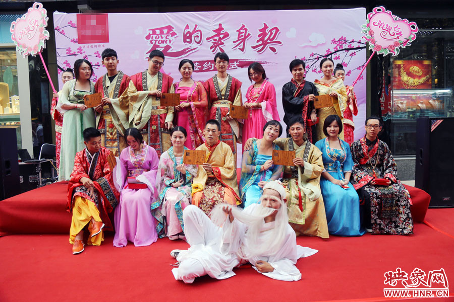現(xiàn)場(chǎng)8對(duì)兒年輕男女舉起“賣身契”集體拍照。
