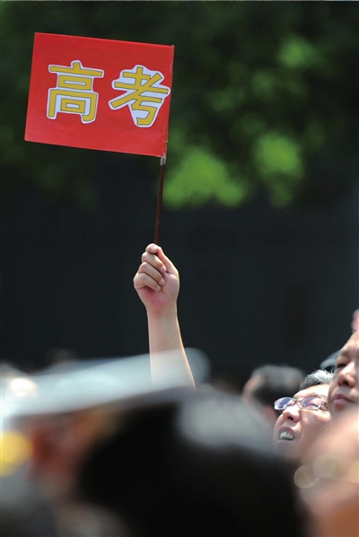 6月7日，在東直門考點(diǎn)外，一名家長(zhǎng)手舉高考的小旗子迎接孩子。資料圖片本報(bào)記者王苡萱攝