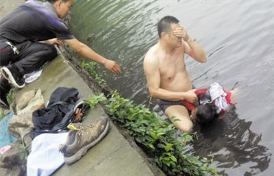 網(wǎng)友貼出民警張光聰一出河水就睜不開眼，用手抹去臉上臟水的照片。