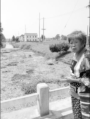 河里長(zhǎng)滿浮萍漂著垃圾，村民有時(shí)不得已用河水應(yīng)急