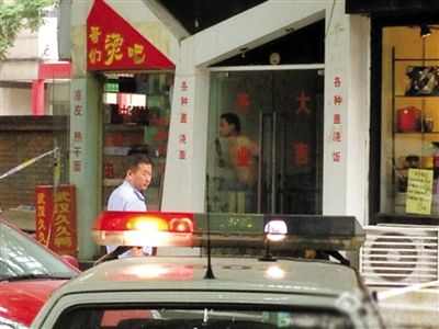 闖入面館的持刀男子與趕來的民警隔著玻璃門對峙，后店內(nèi)一名女童被其劫持。網(wǎng)友供圖