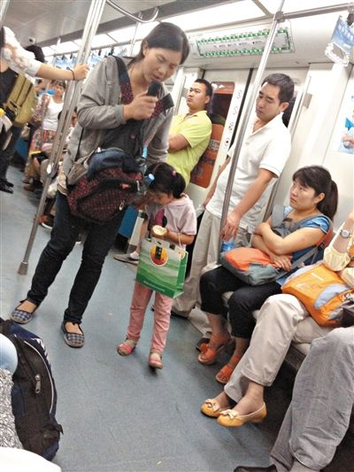 6月27日，舒馨帶一女孩在地鐵十號(hào)線行乞。她因被疑帶多個(gè)不同小孩乞討被警方搜尋。新京報(bào)記者 申志民 攝