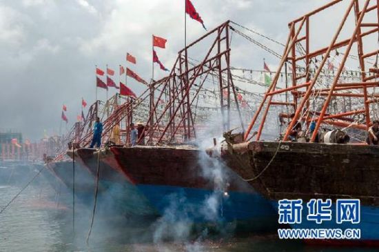 2013年8月1日 南海開漁日 臨高迎新港 8月1日，海南省臨高縣漁民在船上鳴放鞭炮慶祝武蓮港開港。
