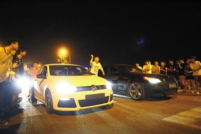 8月24日晚，東壩中街飆車現(xiàn)場(chǎng)，兩輛車并排等待出發(fā)指令，旁邊許多愛好者前來(lái)觀看比賽。新京報(bào)記者