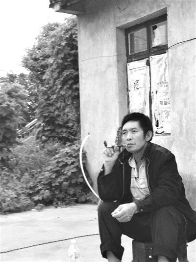 9月12日，陳文才在自己的出租屋旁抽煙。新京報(bào)記者 朱柳笛 攝