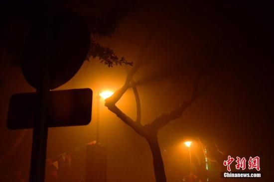 1月31日凌晨，市民行走在煙霧繚繞的南京街頭。當(dāng)天是農(nóng)歷馬年正月初一，南京有限開禁燃放煙花爆竹正逢下霧天，空氣的不流通致使煙花爆竹燃燒后產(chǎn)生的顆粒物不能及時散開，造成整座城市煙霧繚繞。據(jù)當(dāng)?shù)丨h(huán)保部門發(fā)布的信息顯示，空氣質(zhì)量屬重度污染。中新社發(fā) 泱波 攝