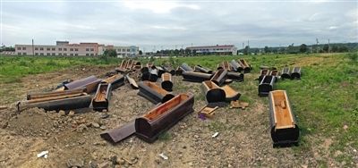 40多副棺木被砸壞后，扔在荒地上。
