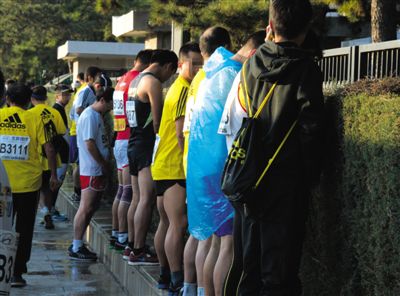 2013年10月20日，北京馬拉松比賽，由于廁位有限，一些選手在綠化帶“就地解決”。圖/IC