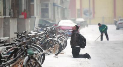 小伙子跪在樓前，一直抬頭看著樓上。 孫立國(guó)/攝