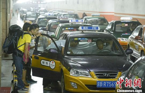 市民在北京西客站出租車候車點準備乘車。中新社發(fā) 侯宇 攝