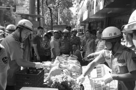 7月11日，瀏陽市北正中路，執(zhí)法人員暫扣張海的水果。這是瀏陽市城管局拍攝的執(zhí)法現(xiàn)場圖。