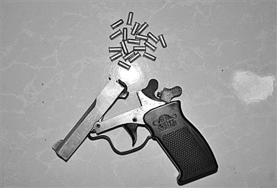 警方從搶劫嫌疑人處起獲的贓款和發(fā)令槍、子彈。警方供圖