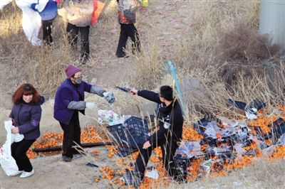 1月4日，連霍高速蘭州市榆中縣和平鎮(zhèn)段，一名警察舉著槍驅(qū)散哄搶橘子的村民。圖/CFP