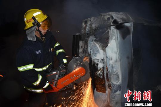 圖為消防人員破拆轎車(chē)，尋找4萬(wàn)元現(xiàn)金。嚴(yán)光濤 攝