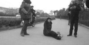 鄭大姐坐在地上，警方趕到進行施救。（視頻截圖由警方提供）