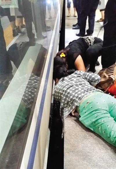 一女子趴在站臺(tái)上，救跌入列車和站臺(tái)間隙的男童。網(wǎng)友璀璨的星月夜 攝