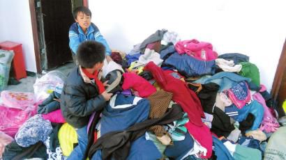 學(xué)生在幫忙整理收到的捐贈(zèng)衣服。得石中心校供圖