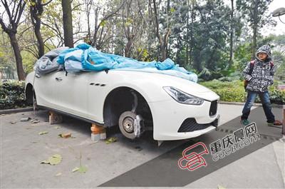 昨日，停放在重慶大學B區(qū)的一輛瑪莎拉蒂豪車被架在幾塊磚頭上，車輪不翼而飛。 重慶晨報記者 胡杰 攝