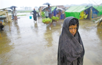5月14日，緬甸若開邦實(shí)兌難民營(yíng)，羅興亞族難民在雨中行走。熱帶風(fēng)暴“馬哈森”即將登陸緬甸，這里的難民開始乘船撤離。