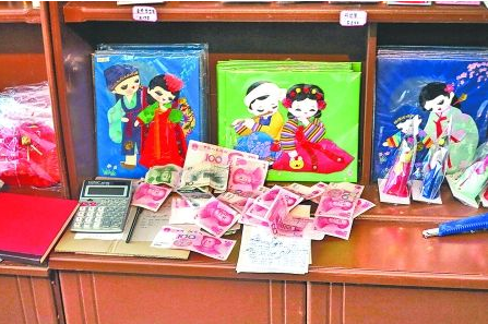 　　2012年6月21日，在朝鮮羅先特別市的一家商店里，柜臺上散落著一些人民幣。在朝鮮，人民幣比本國