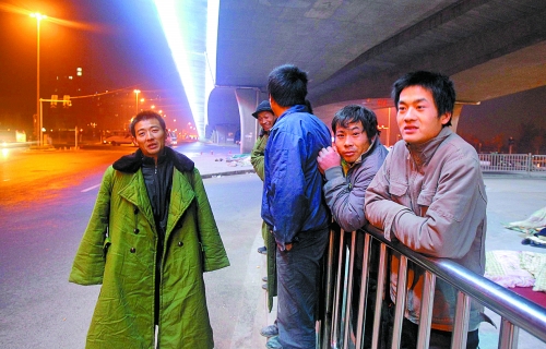 冬夜里，農(nóng)民工在橋下等著干活兒。