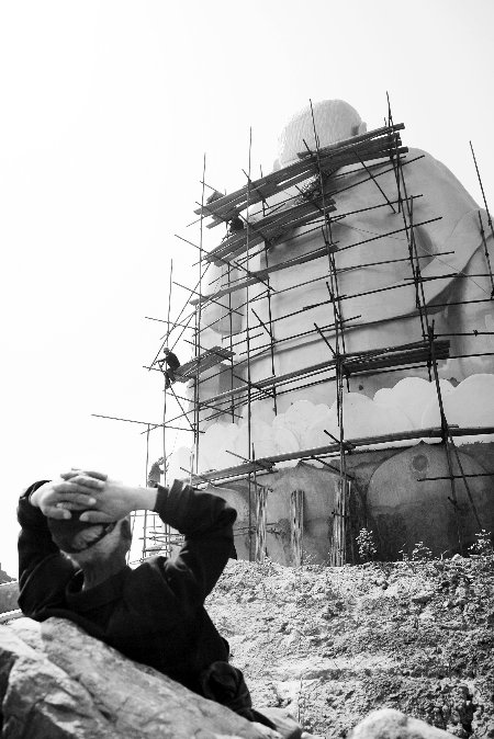今年4月26日，工作人員將帆布蓋在“佛像”頭像上