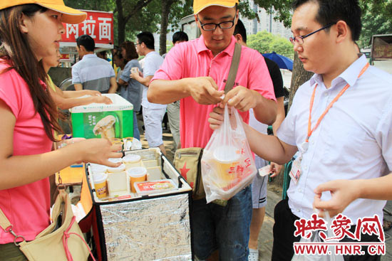圖為徐貴雨和一名勤工助學(xué)的學(xué)生在街頭義賣快餐。