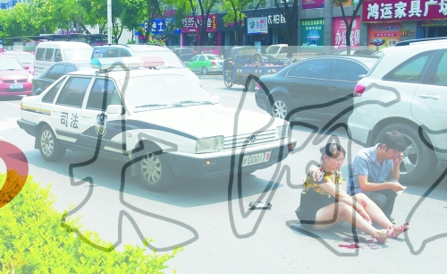 事故發(fā)生后，警車司機(jī)（右）下車查看傷者并撥打120，倆“領(lǐng)導(dǎo)”穩(wěn)坐車內(nèi)引發(fā)圍觀者不滿。