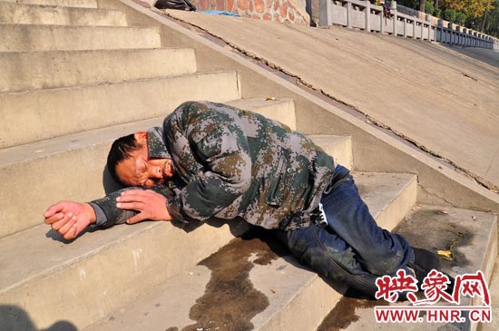 這名男子的衣服以及褲子全濕透了，水從衣褲里流出來，嘴里散發(fā)著濃烈的酒氣。
