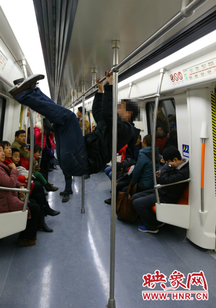 地鐵試乘日，一男子在車廂內(nèi)攀爬扶手自娛自樂