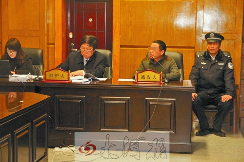 庭審現(xiàn)場，被告人坐在律師身旁為自己辯護(hù)。