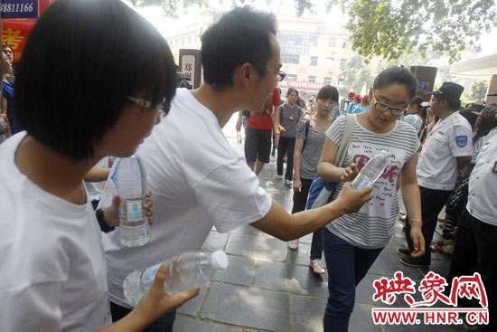 志愿者為剛剛考試完的考生送上1瓶冰凍的冰露·純悅，消暑解渴為考生加油