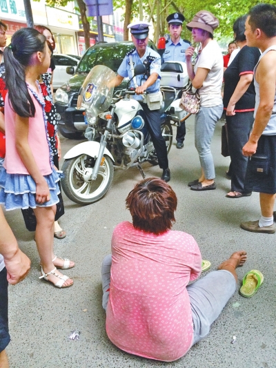 在鄭州優(yōu)勝南路東三街交叉口向東100米處，一名短發(fā)中年女子平躺在路南快車道上，身旁還有一只掉落的拖鞋