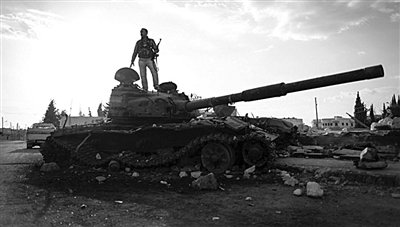 9月8日，敘利亞Zabadani，一名敘利亞反對派武裝人員站在廢棄的政府軍坦克上。