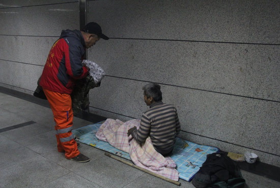 在鄭州一處地下通道，孫德坤挑了幾件衣服送給了流浪者