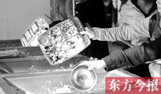 11月27日，河南中醫(yī)學(xué)院餐廳，一名同學(xué)將餐盤內(nèi)沒吃完的食物倒入餐具回收車內(nèi)