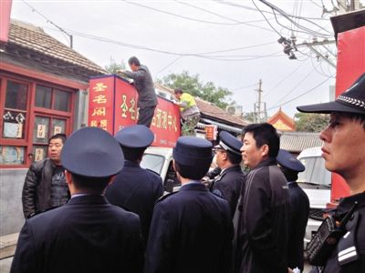 昨日下午,東城區(qū)工商、城管、公安等部門,對雍和宮附近的預(yù)測中心進(jìn)行清理整頓,站在車頂?shù)膬擅と苏鸪患摇邦A(yù)測中心”的招牌。因雍和宮、白云觀等文化景點(diǎn)外聚集大量算命先生,被媒體稱為“算命一條街”。本版攝影/新京報(bào)記者 李寧 攝