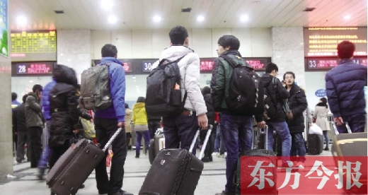 鄭州火車站東廣場售票大廳，幾名學(xué)生在售票窗口前躊躇