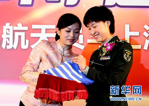 11月1日，航天員劉洋（右）在為“愛心”毛衣編織最后的收尾針。