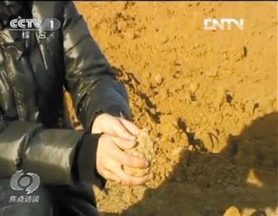 麻剛沙系麻剛石粉碎而成。記者找到一塊麻剛石，一捏就碎成粉末，硬度非常差。央視截圖