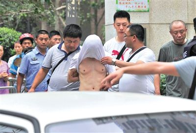 昨日，成都警方抓捕時(shí)與毒犯發(fā)生槍?xiě)?zhàn)。一名男犯罪嫌疑人被警方押出。